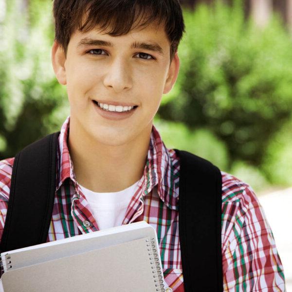 A male student holding notebooks